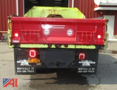 Ram 5500 dump truck rear with plow mount, red dump body, green undercarriage, dual tail lights, mud flaps, dealership stickers