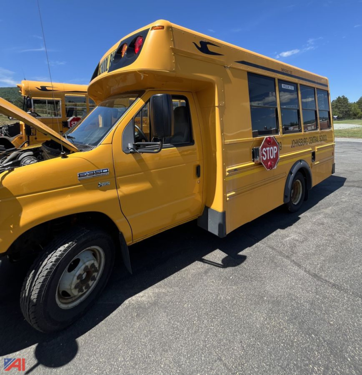 Ford E-450-based 2011 Micro Bird cutaway school bus side view showing yellow body, stop sign, and rear window panels.