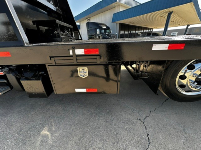 Flatbed tow truck side view showing toolbox with latch under truck bed and wheel, 2018 Freightliner M2106 chassis