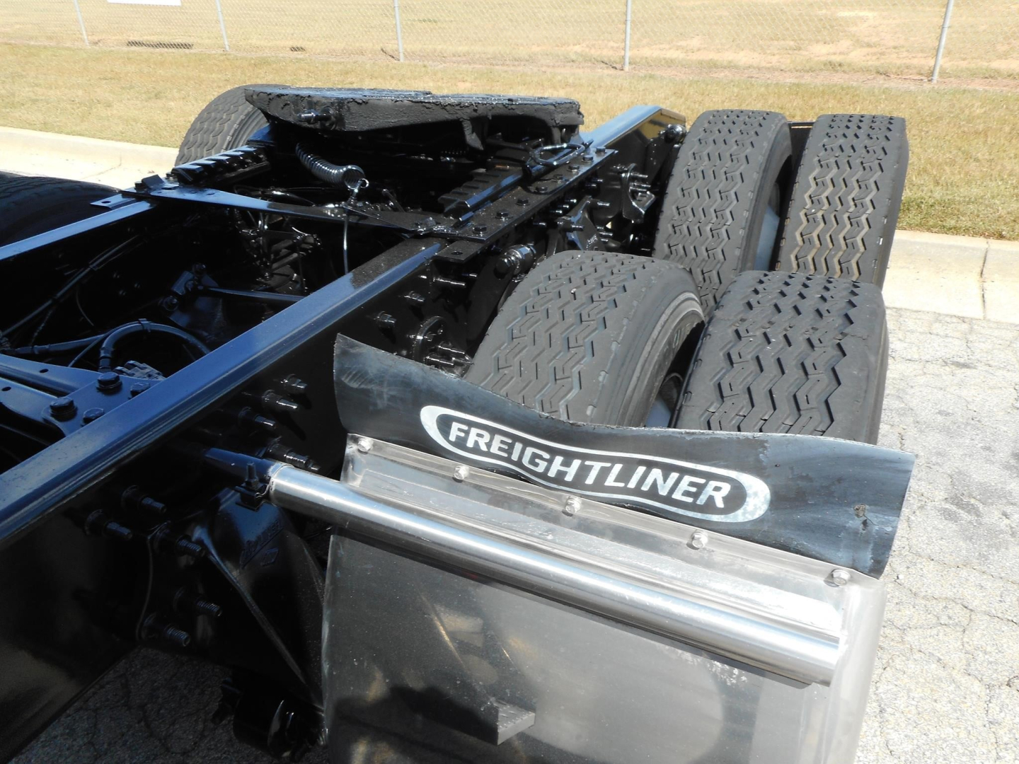 Freightliner Cascadia 126 chassis with tandem rear axles and fifth wheel area visible; Freightliner badge on mudguard.