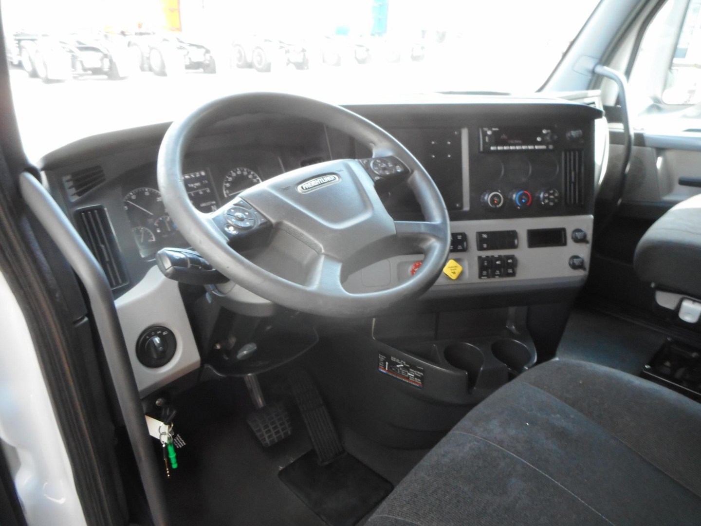 Truck cab interior showing steering wheel, dashboard, and control panel in a Freightliner Cascadia 126.
