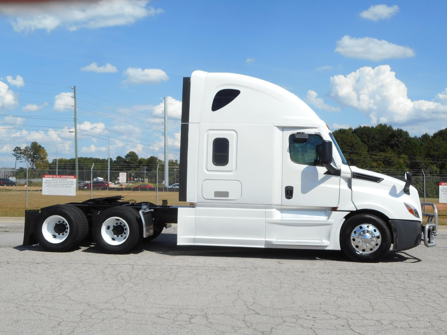 Freightliner Cascadia 126 sleeper tractor side view showing connected chassis, white exterior, dual rear axles and clean cab with windows and mirrors.