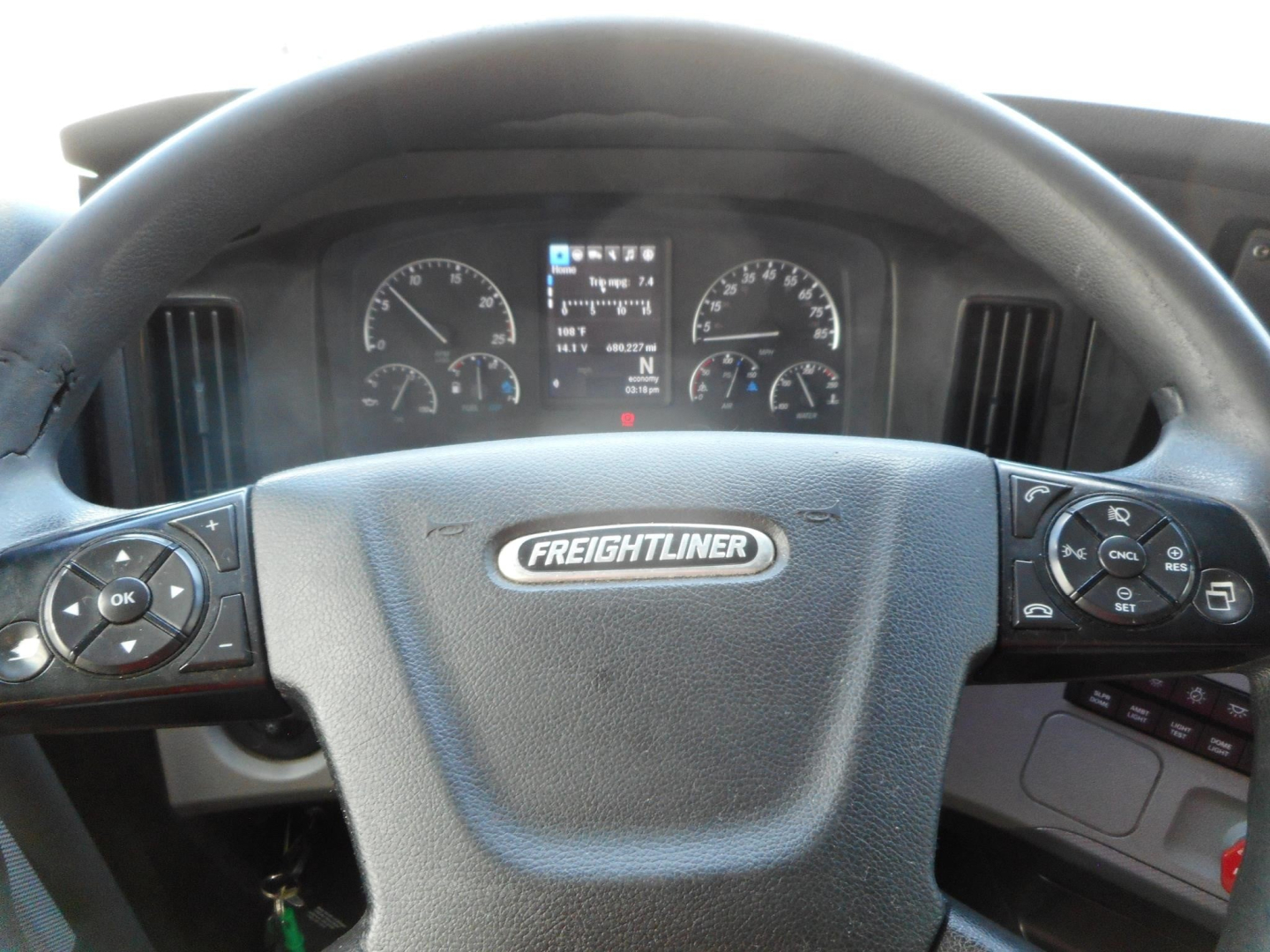Freightliner Cascadia steering wheel and dashboard with instrument cluster; central badge reads FREIGHTLINER.