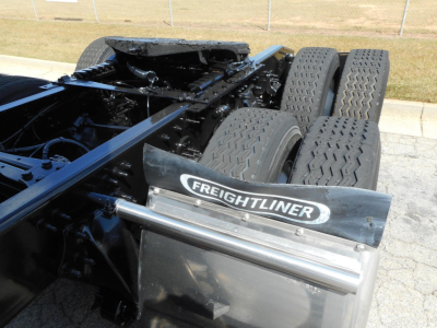 Freightliner Cascadia 126 chassis with tandem rear axles and fifth wheel area visible; Freightliner badge on mudguard.
