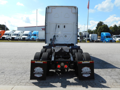 Rear view of a 2022 Freightliner Cascadia 126 tractor with fifth wheel, dual rear axles, and black mud flaps showing 50 years Peach State