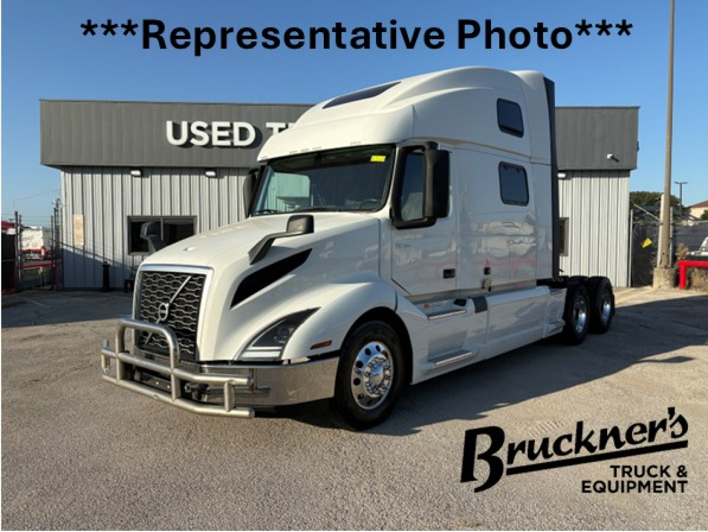 Truck cab in service bay showcasing 2025 Volvo VNL64T860 sleeper tractor with chrome bumper and grille, white exterior, aerodynamic hood, and dual rear axles.