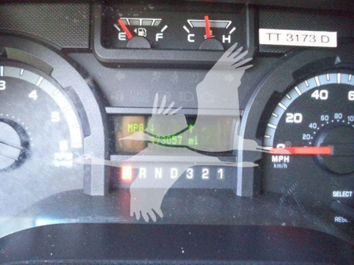 Dashboard view of a 2011 Ford E450 showing gear selector PRND321, speedometer, and fuel gauge; odometer area visible with indicator readings.