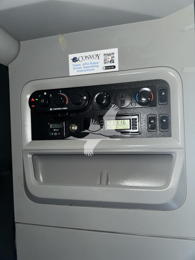 Conventional sleeper truck dash showing HVAC controls, radio, and control panel; label with Convoy offering driver operating instructions in upper center.