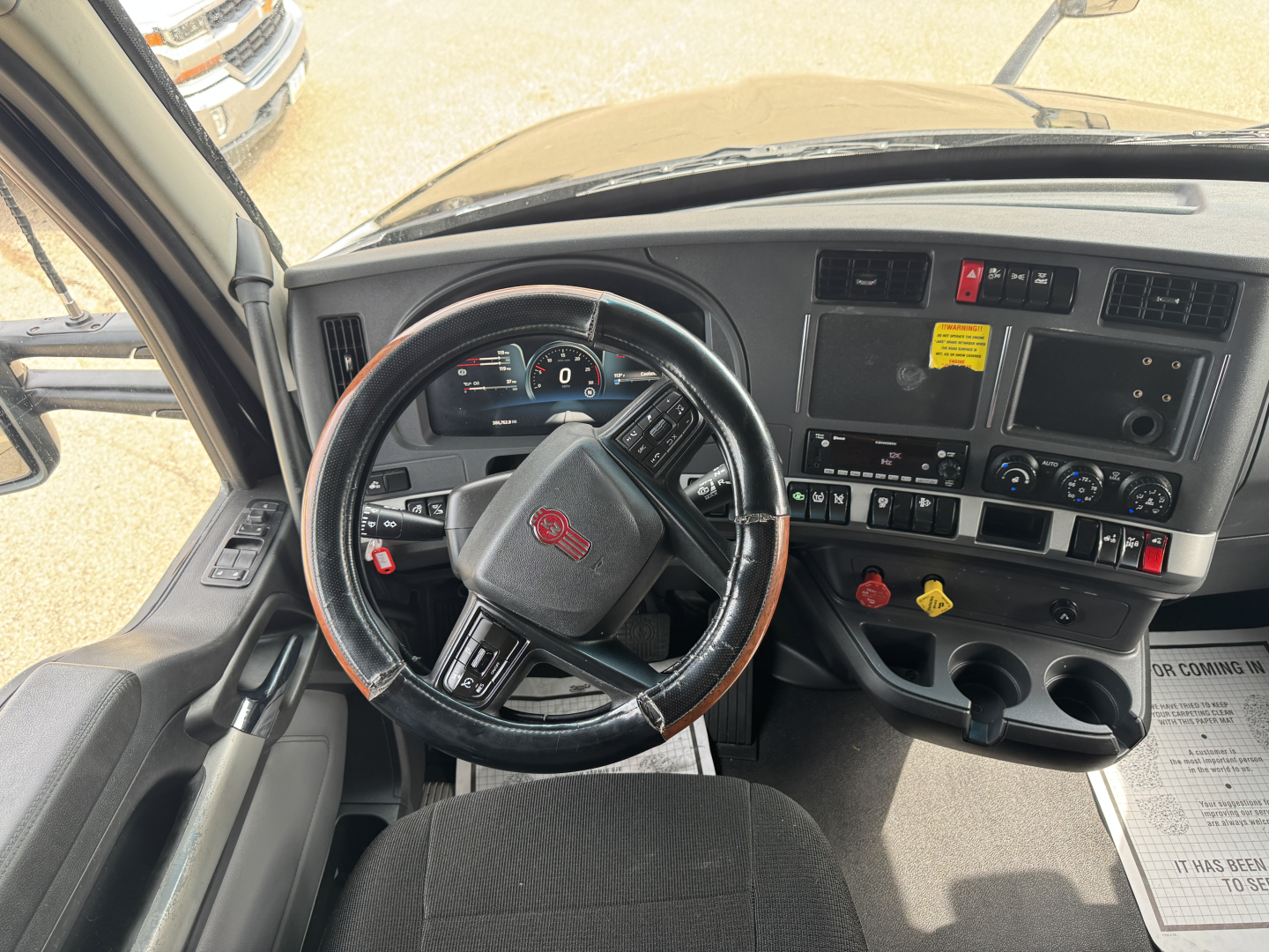 Kenworth T680 truck interior steering wheel and dashboard with gauges and controls visible.