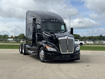 Kenworth T680 conventional sleeper truck in black, front three-quarter view showing chrome grille, headlights, and cab with two side mirrors.
