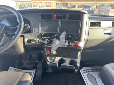 Kenworth T680 dash and center console showing driver's pedal area and dashboard controls.
