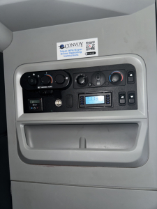 Kenworth T680 dash area showing climate controls, radio, and a sticker with Convoy instructions.