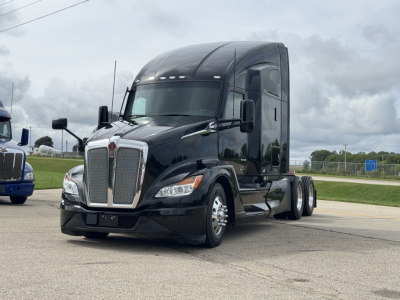 Kenworth T680 conventional sleeper truck in view showing front grille and cab with dual rear axles