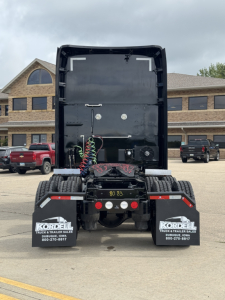 Kenworth T680 rear view showing chassis and fifth wheel with air lines and bumper mud flaps with Kordel logos.