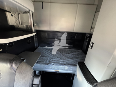 Kenworth T680 sleeper cab interior showing bunk bed area and storage compartments.