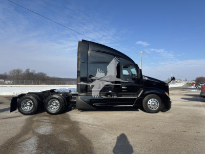 Kenworth T680 conventional sleeper truck side view showing black paint with large graphic eagle decal