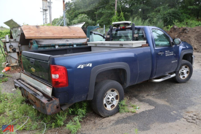 Chevrolet Silverado 2500HD pickup truck 4x4 in blue, rear bed with equipment; visible model badges on door and tailgate; worn bumper and utility tools in bed.