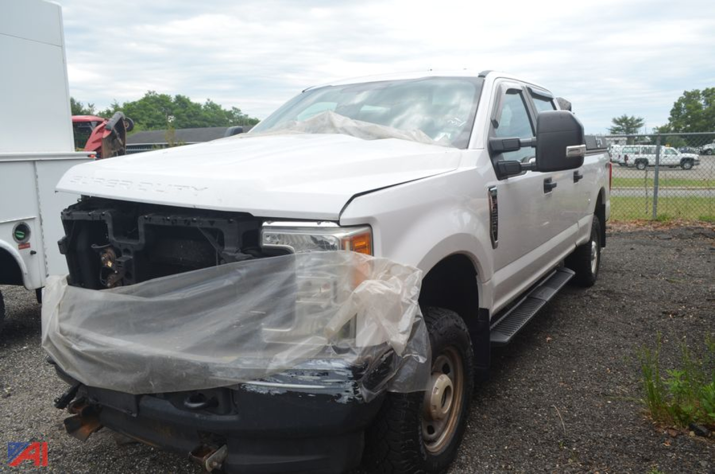 2017 Ford F-250 Super Duty pickup truck in a salvage state with front-end damage; plastic protective cover over front bumper area, exposed radiator and left headlight area, side step rails visible.