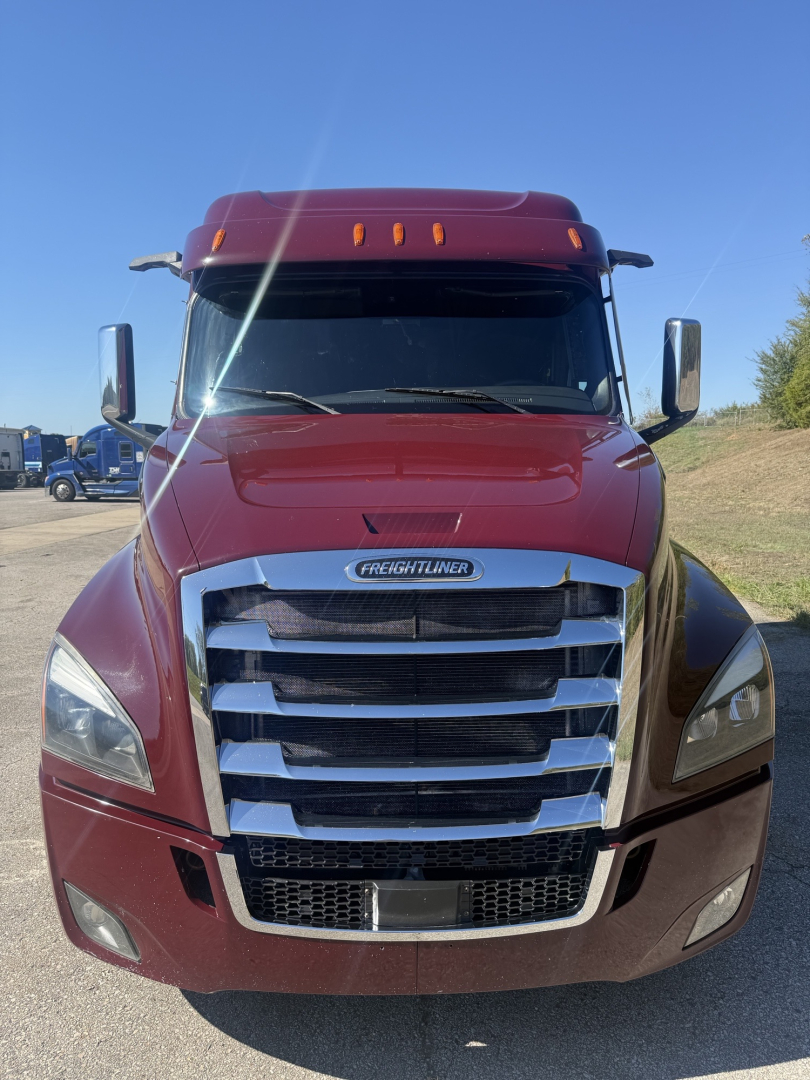 Freightliner Cascadia 126 front view showing chrome grille, headlights, and maroon cab with large windshield and side mirrors.