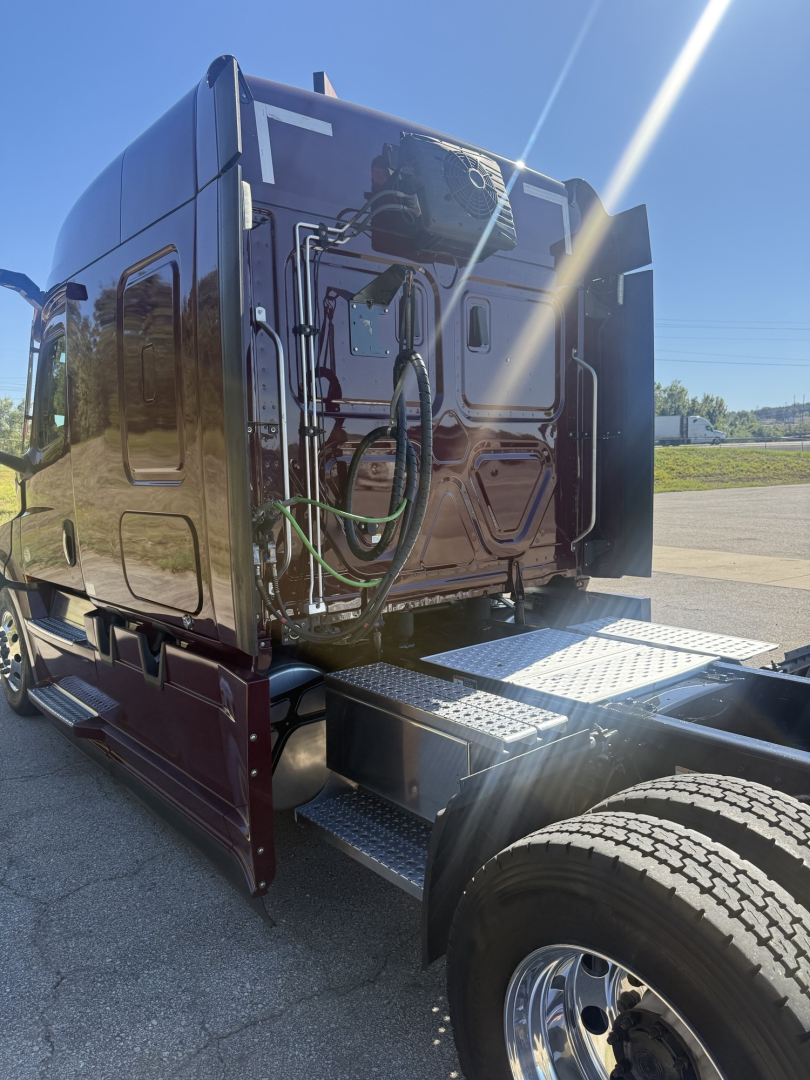 Truck cab rear view showing green air lines and steps on Freightliner Cascadia 126 sleeper.