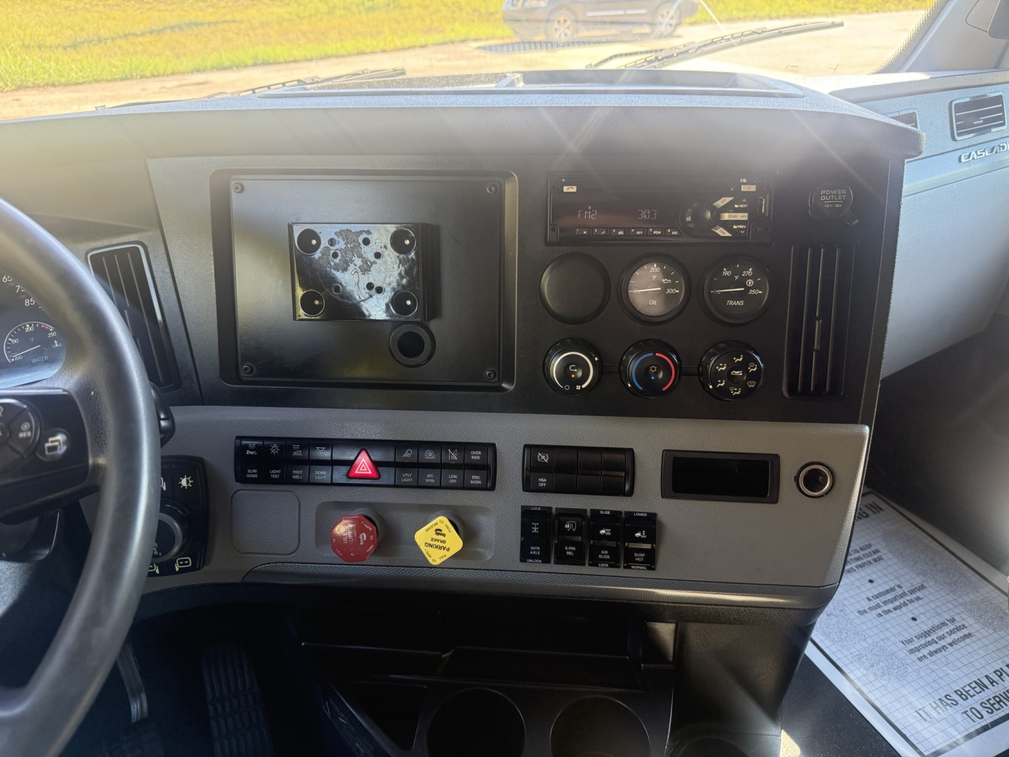 Dashboard of a Freightliner Cascadia126 truck showing empty radio/nav slot, multiple gauges, climate controls, and switch panel; VIN and stock info not visible in image.