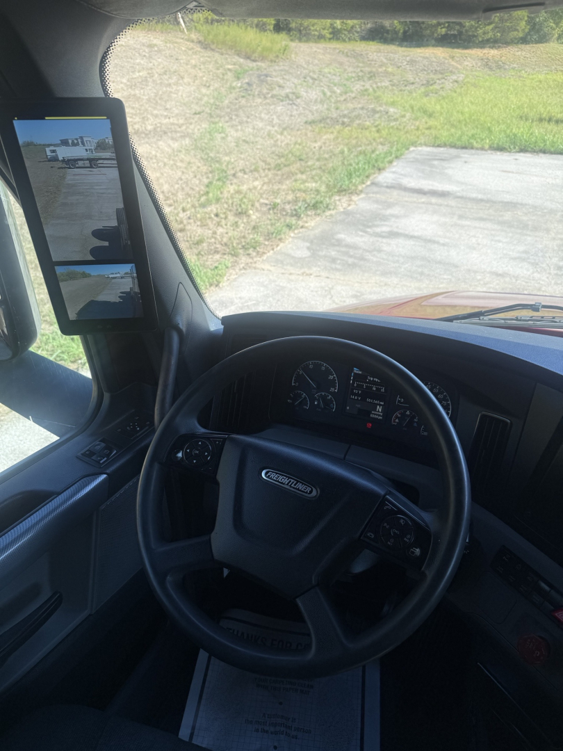 Freightliner Cascadia126 truck interior showing steering wheel and dashboard with side mirror displays.