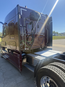 Truck cab rear view showing green air lines and steps on Freightliner Cascadia 126 sleeper.