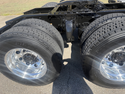 Freightliner Cascadia126 trucks showing dual rear axles with polished chrome rims and heavy-duty tires.
