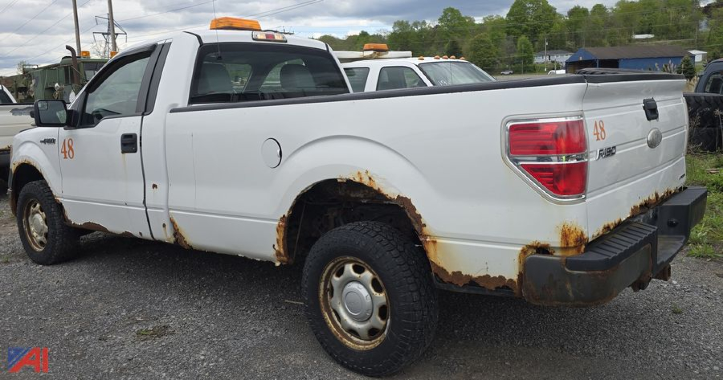 Ford F-150 pickup truck crew cab rear side showing rust on body, white paint, orange clearance lights, wheel wells, and rear bumper.