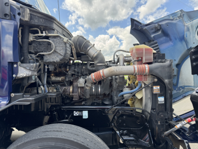 Kenworth T680 engine bay showing turbocharger, air intake, radiator reservoir, hoses, and surrounding components.