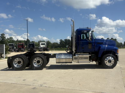 Blue Mack PI64T truck cab and chassis in side profile showing fuel tanks, exhaust stack, and wheels.