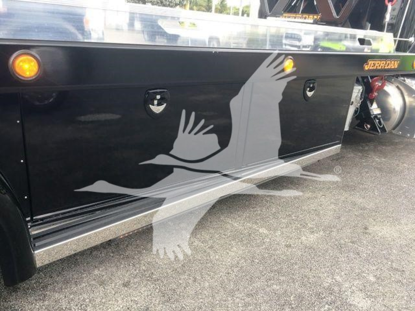 Truck side view showing Peterbilt 337 rollback side panel with graphics and recessed toolboxes.