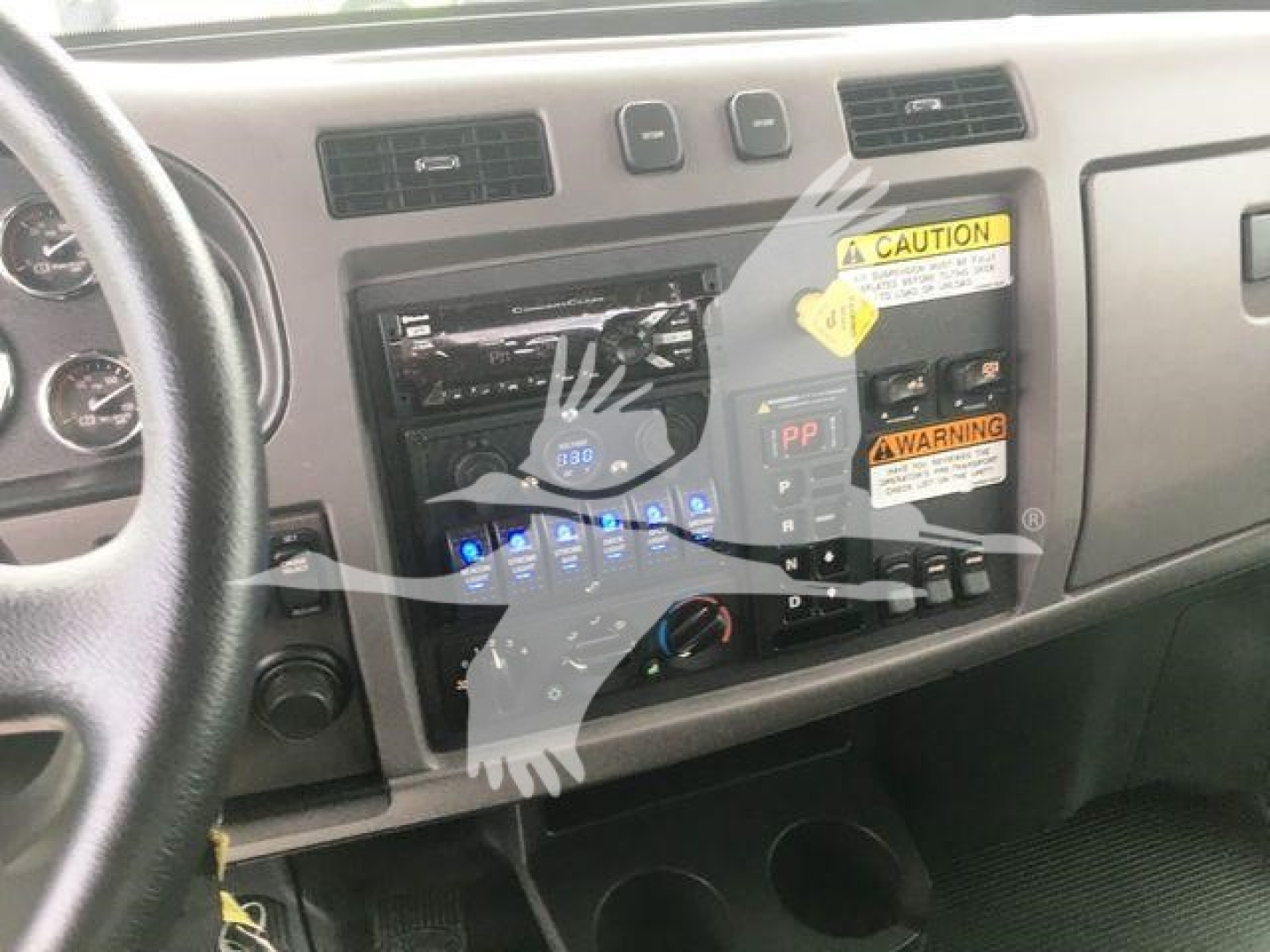 Peterbilt 337 dashboard area with radio/CD unit and warning stickers; interior view of dashboard and center console.