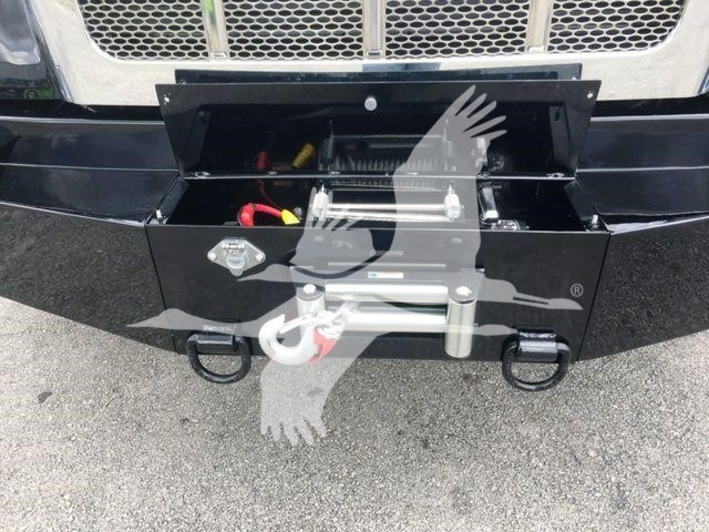 Peterbilt 337 front with mounted front hitch and storage box; visible components include winch/boom mount and electrical wiring inside the open toolbox