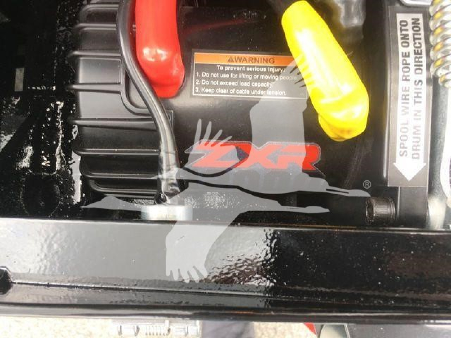 Peterbilt 337 rollback truck engine bay with visible DXR (likely parking or battery area) label and yellow battery terminal cover.