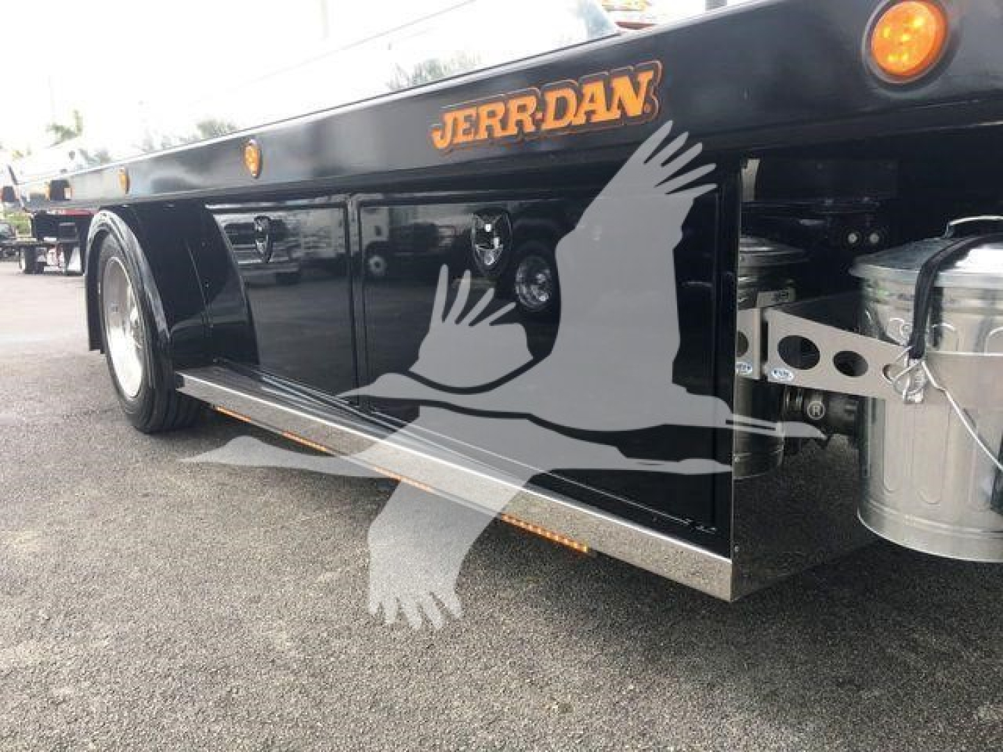Peterbilt 337 rollback truck side with storage compartments, 'JERR-DAN' branding on bed rail, stepside panel, reflective chrome accents.