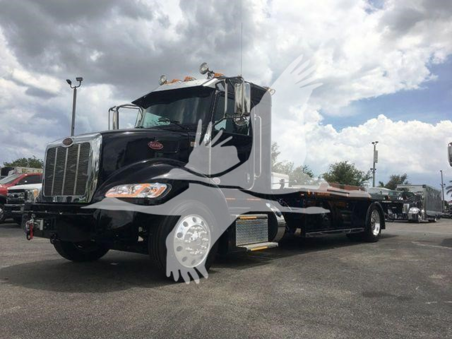 Peterbilt 337 rollback truck in black with chrome grille and sleeper cab, side view showing flatbed and dual rear wheels.