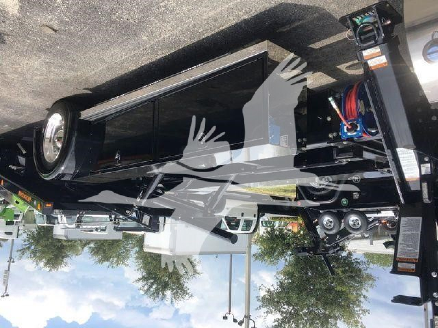 Peterbilt 337 rollback truck with equipment mounted, front grille and storage compartments visible, logo and hydraulic lines in view.