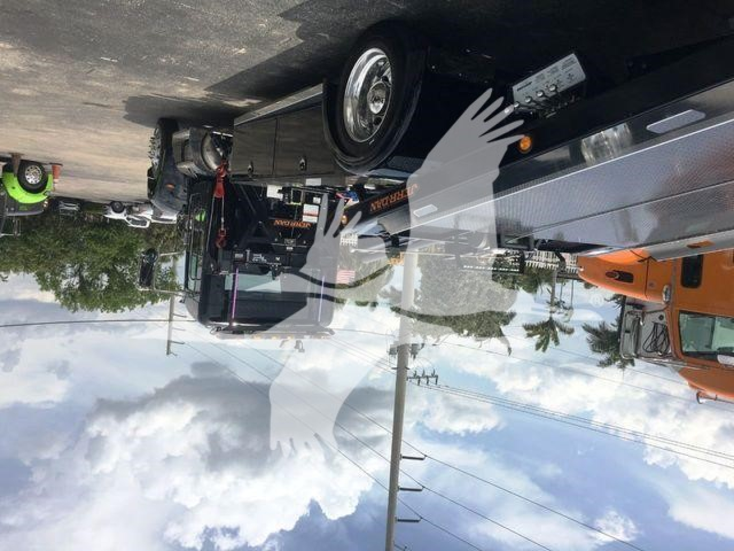 Flatbed tow truck trailer with Peterbilt 337 cab visible, chrome side rails and wheel hub; text on tag near bed reads not fully legible.