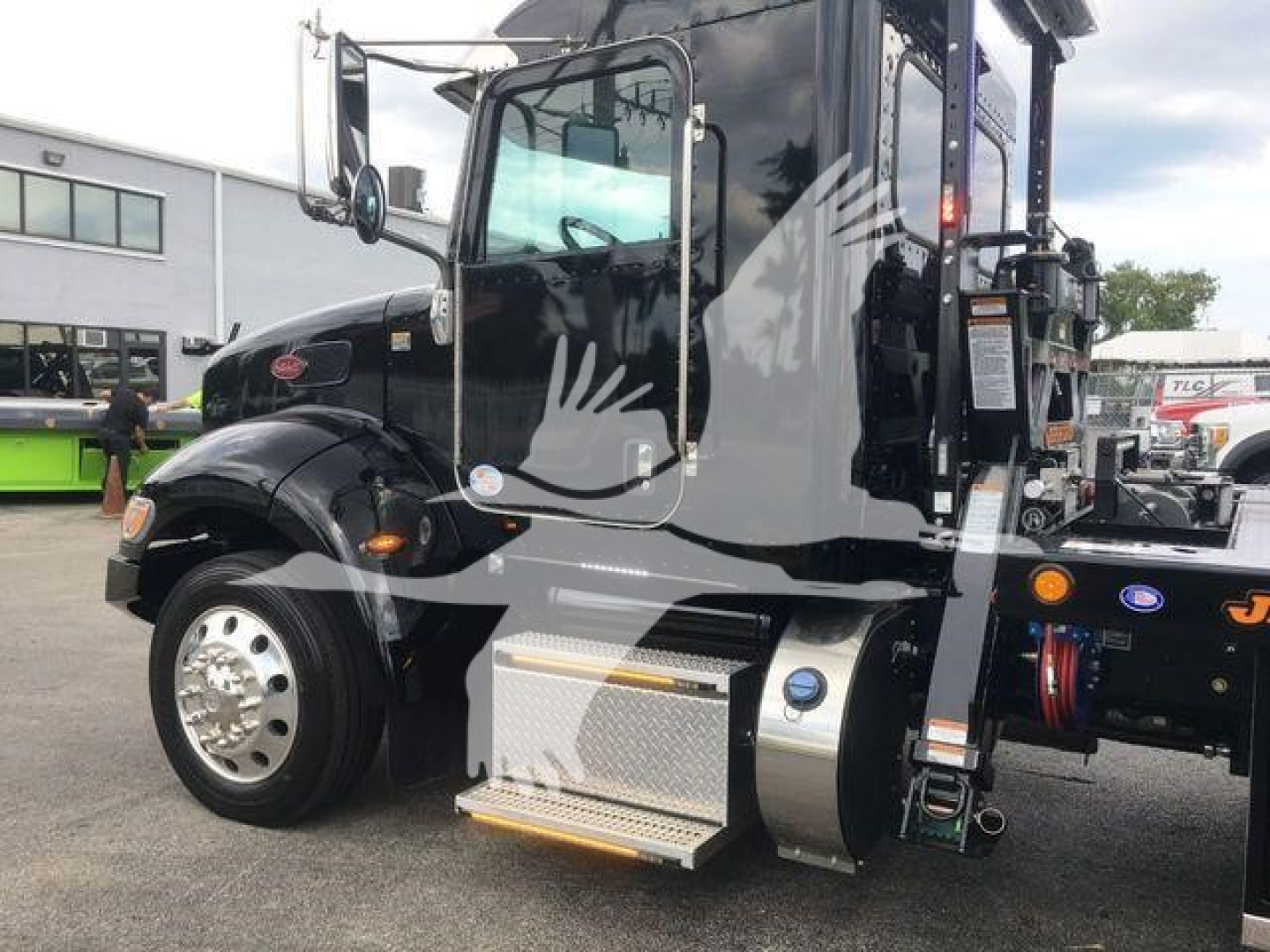 Peterbilt 337 truck cab with stepside configuration, black exterior, side steps, fuel tank, and rear rollback equipment visible.