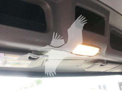 Interior view of a 2022 Peterbilt 337 dashboard area with overhead mirrors and a sun visor light; sticker labels are visible but unreadable due to angle.