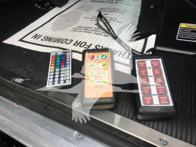 Trucks equipment showing three remote controls on a truck bed, with labels and instruction sheet in background.
