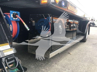Peterbilt 337 rollback truck side view showing external fuel or hose reel with blue accents and black polished side panels.