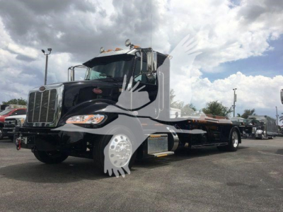 Peterbilt 337 rollback truck in black with chrome grille and sleeper cab, side view showing flatbed and dual rear wheels.