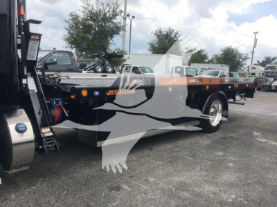 Peterbilt 337 rollback truck side view showing flatbed with logo and components