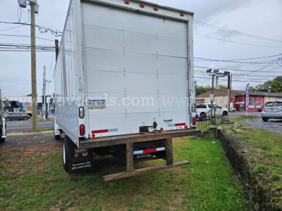 Rear view of a box truck with a large white cargo trailer, showing back doors, red taillights, bumper, and wheel well; stock number 32136-61 visible on the trailer side.