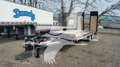 Flatbed trailer with dual gooseneck and ramps showing JandY Beaver branding and equipment in a gravel lot.