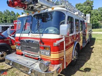 Fire truck cab over engine with COUNT on windshield and ladder rack, red and cream color scheme, front chrome bumper and grille.