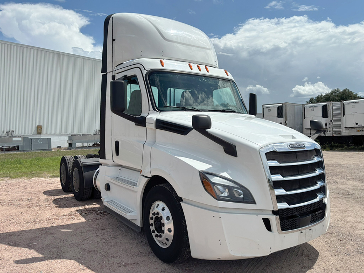 Freightliner Cascadia 126 truck in white front-three-quarter view showing grille, headlights, and sleeper cab.