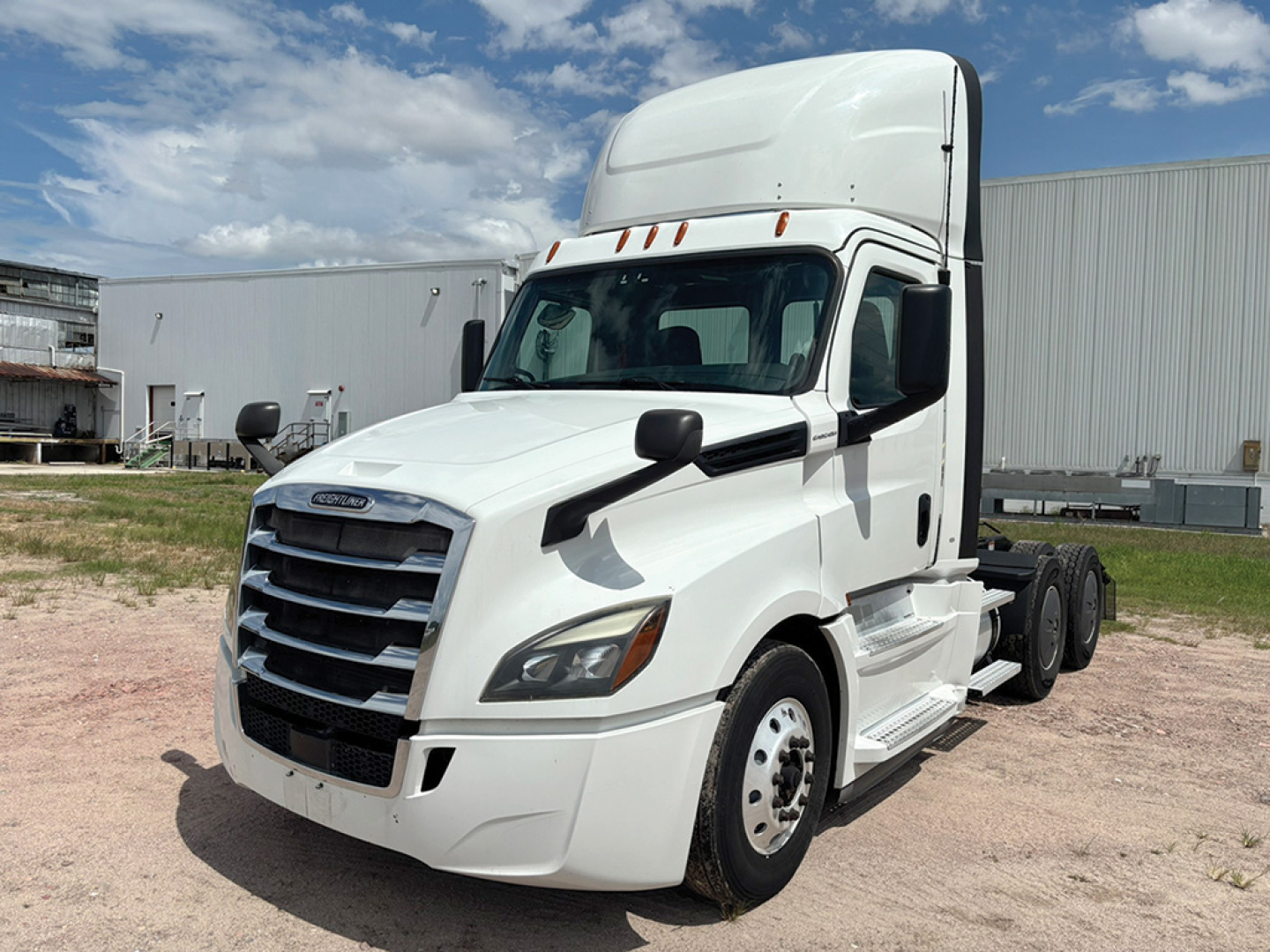 Freightliner Cascadia 126 tractor in white, front-left view, with high-roof sleeper, showing grille and headlights.